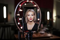 Smart phone screen mounted on ring light with vlogger filming make-up vlog photography portrait adult.