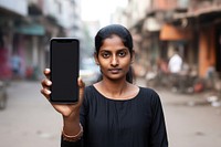 Close up mobile phone at front holding by indian woman screen selfie street.