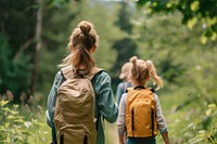 Small children with mother hiking outdoors nature adventure.