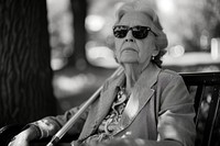 A blind woman sunglasses portrait sitting.