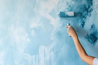 Side photo of woman paint a wall by paint roller blue backgrounds paintbrush.