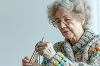 Mature woman watching tutorials for knitting adult concentration grandmother.