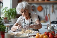 Mature woman watching tutorials for making pasta cooking adult grandmother.