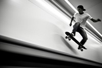 A young Latino skateboarder in a blank white tee footwear motion black.