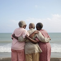 3 friends african-american elderly sea outdoors hugging.