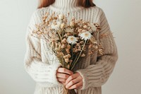 Person holding flowers sweater plant white.