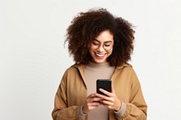 Positive curly haired ethnic woman uses mobile phone checks messages and reads news holds modern cellular in hands laughing smile adult.