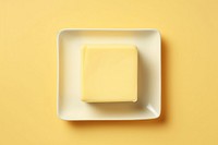 Butter on a white plate yellow food yellow background.
