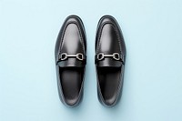 Black soft leather loafers with buckle footwear shoe blue background.