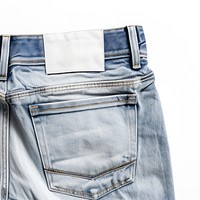 Back side of empty label on folding jeans put on white background shorts denim pants.