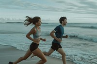 Couple wearing sportwear running together jogging sports beach.