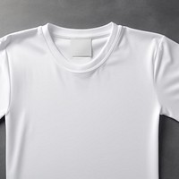 Empty white fabric label tag printing on flatlay t-shirt sleeve undershirt clothing.