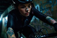 Female cyclist riding a bike with tattoos portrait helmet adult.