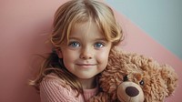 Studio shot of a child hugging a large realistic bear portrait toy representation.