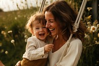 Mother and toddler outdoors laughing portrait.
