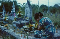 Thai woman crying tombstone cemetery outdoors.