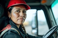 Latinx women truck driver vehicle driving hardhat.