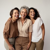 Three diverse women in different ages laughing standing adult.