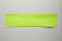 Piece of neon-green paper adhesive strip text white background rectangle.