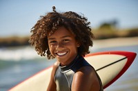 Black boy surfer surfing portrait outdoors smiling.