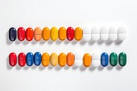 Assorted pill shapes and colors white background organization arrangement.