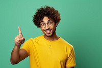 Indian man with curly hair portrait glasses pointing.