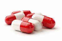 Pile of three capsules pill red white background.