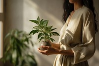 A person holding a plant adult houseplant flowerpot.