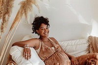 Happy pregnant woman relaxing on a white sofa adult accessories relaxation.