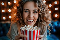 Happy woman eating popcorn while watching movie adult smile food.