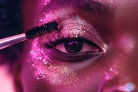 Super close up eye of black woman applying mascara on her lashes cosmetics glitter adult.