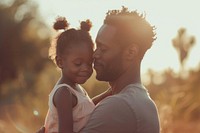 Black man holding his daughter portrait outdoors adult.