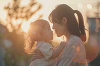 Woman holding her daughter outdoors portrait nature.