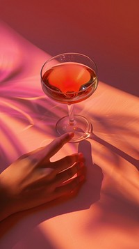 Hand holding cocktail glass drink red cosmopolitan.