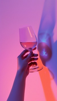 Hand holding wine glass purple drink pink.