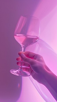 Hand holding wine glass purple drink pink.
