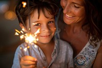 Boy and mom holding sparkler sparks adult togetherness.