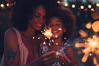 Girl and mom holding sparkler adult togetherness illuminated.