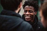 Black person interacting with friends laughing adult smile.