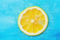 Slice of lemon underwater or in water with splashing and droplet top view flat lay on blue background backgrounds fruit slice.