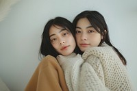 Two asian young women hugging portrait sweater adult.
