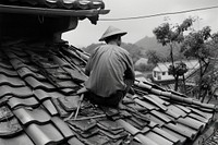 A man repair of tiles on the roof adult architecture installing.