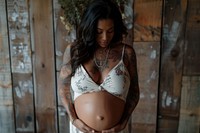 Pregnant woman holding her belly underwear lingerie bra.