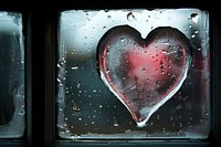 Heart icon written on misted window glass transparent.