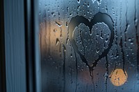 Heart silhouette written window glass condensation.