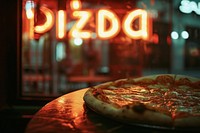 Pizzaria food advertisement illuminated.