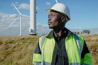 Male engineer wearing hard hat windmill standing outdoors.