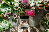 Hands typing on a laptop outdoors garden computer.