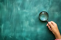 Child holding magnifying glasses backgrounds blackboard photo.