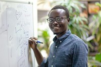 African man writing whiteboard working smiling.
